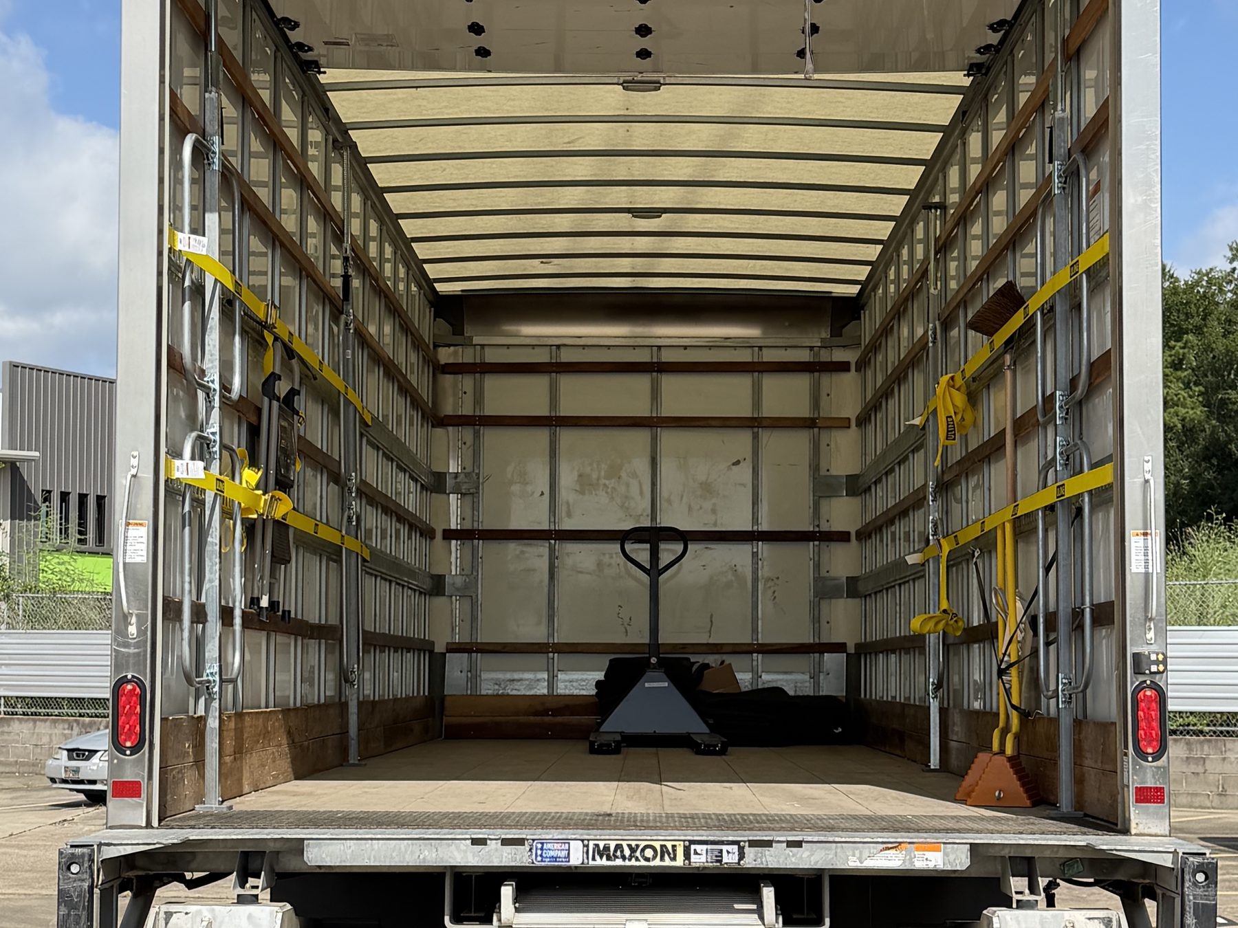 Rear view of the 26-foot box with the Maxon liftgate deployed, pallet jack and moving blankets aboard