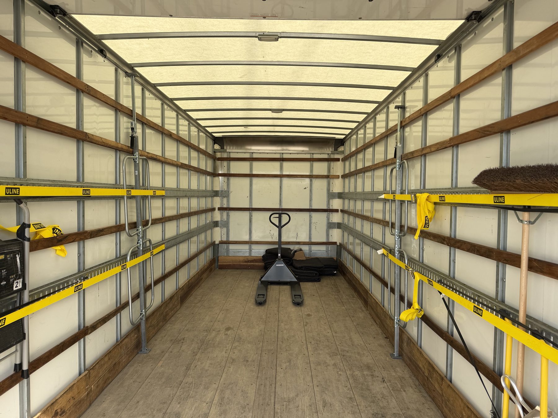 Interior of the 26-foot dry van box looking forward — flat hardwood floor, E-track both walls, translucent roof