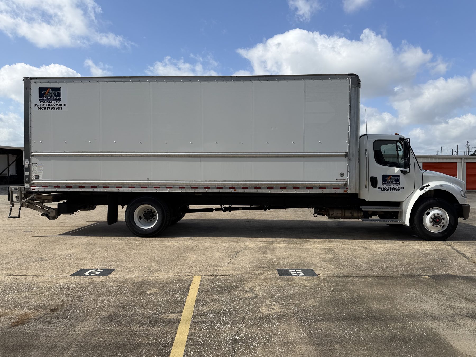 Alinea Transport 26-foot box truck full side profile with company markings and liftgate